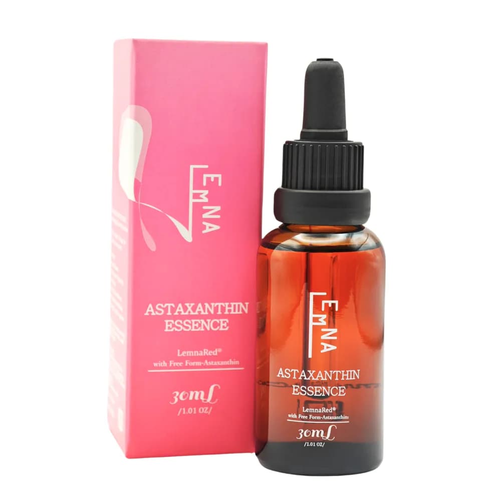 粉紅色盒裝與棕色玻璃滴管瓶並列，包裝印有 EMNA、ASTAXANTHIN ESSENCE、30ml 等白色文字。