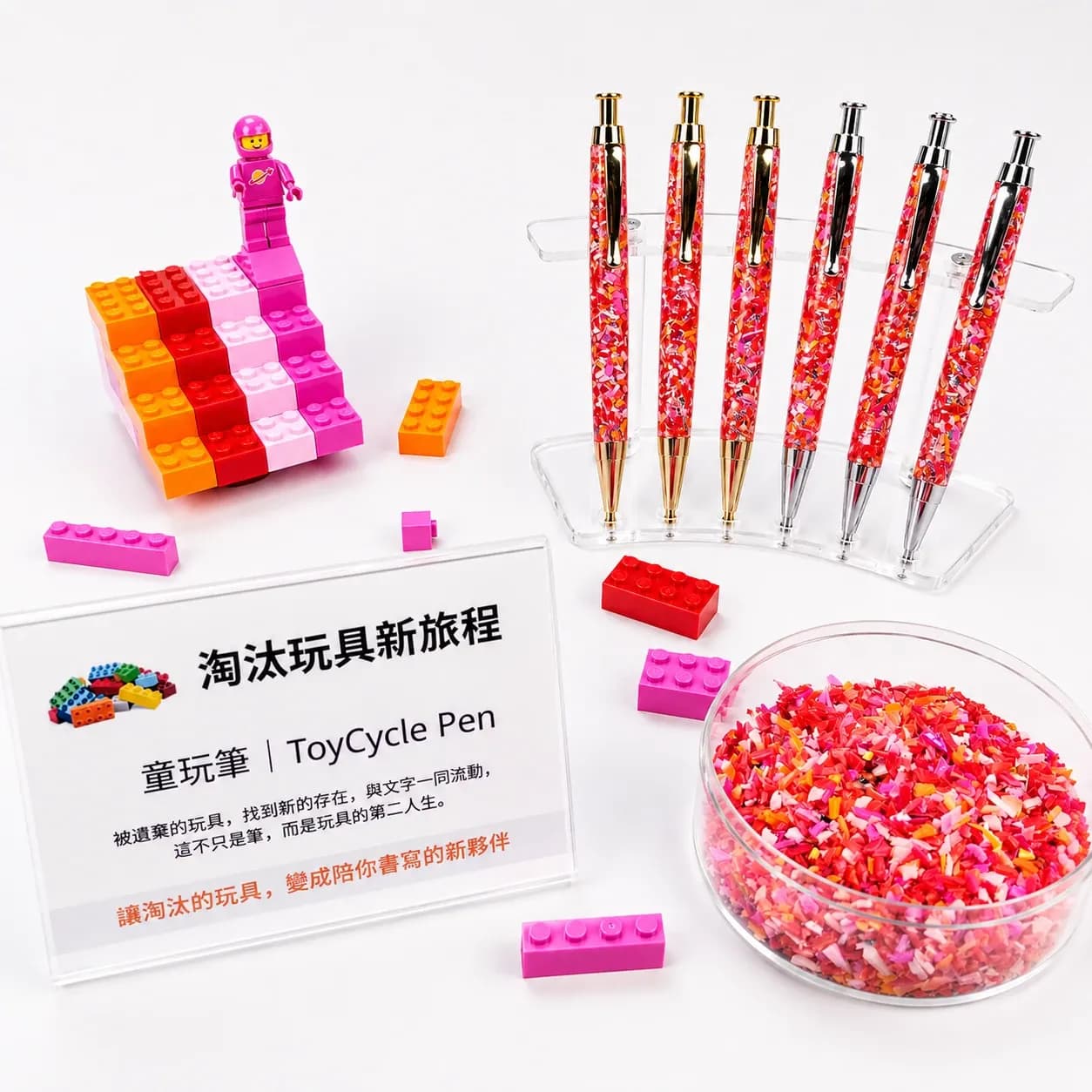 白色桌面上排列六支彩色碎料筆,旁有裝滿彩色碎片的玻璃碗、積木人偶與「淘汰玩具新旅程」說明牌。