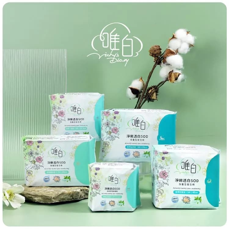 淺綠背景前擺放五包印有花卉圖案與唯白標誌的淨嫩透白SOD包裝,右後方立著棉花枝,左下有白花與木板。