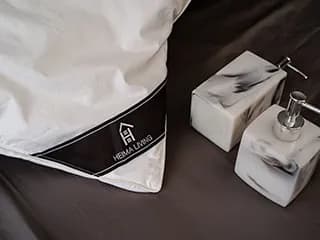 HEIMA Living 的枕頭和香皂瓶,展示品牌標誌。